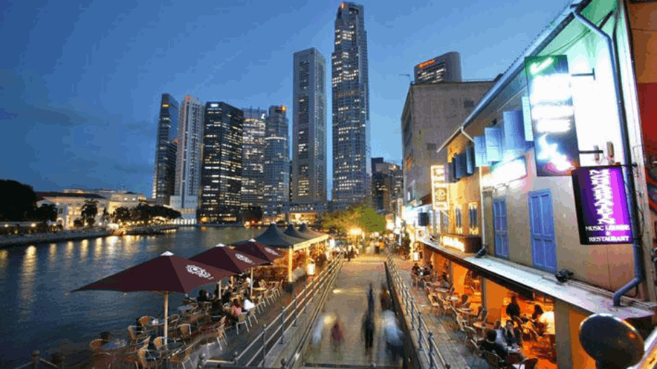 Boat Quay at night with riverside dining, city lights and Singapore skyline views, a lively evening spot for visitors exploring Singapore after dark.