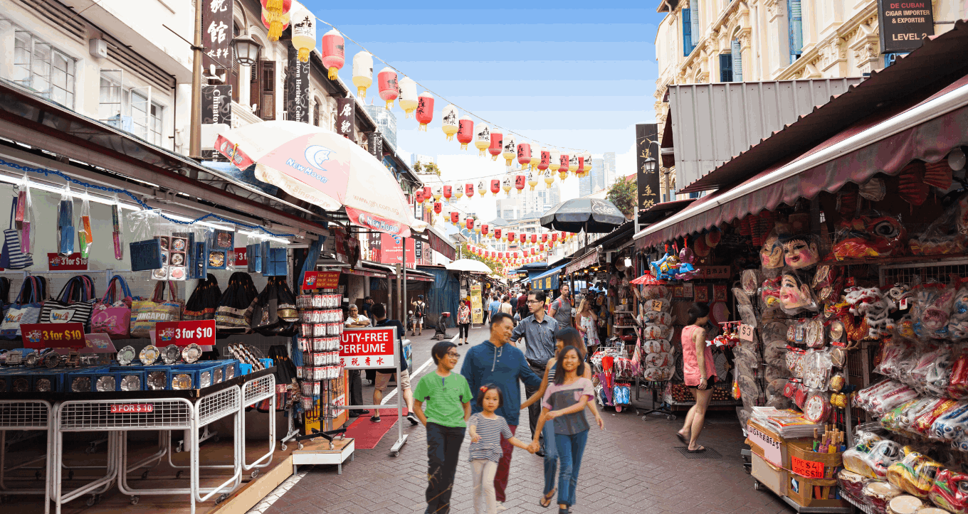 Family walking through Chinatown in Singapore, enjoying the festive decorations during Hari Raya Haji.