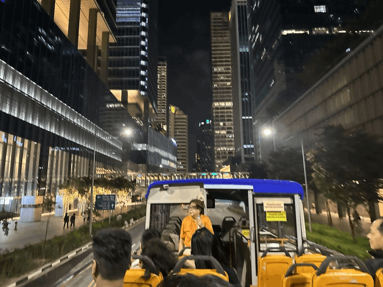Tourists enjoying the FunVee Open-Top Night Tour through Singapore’s brightly lit downtown skyscrapers.