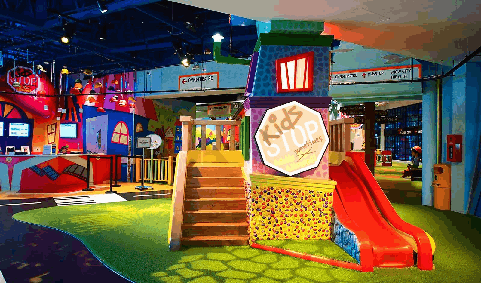 Colourful indoor play area at KidsSTOP, with interactive science exhibits, a mini slide, and learning zones.