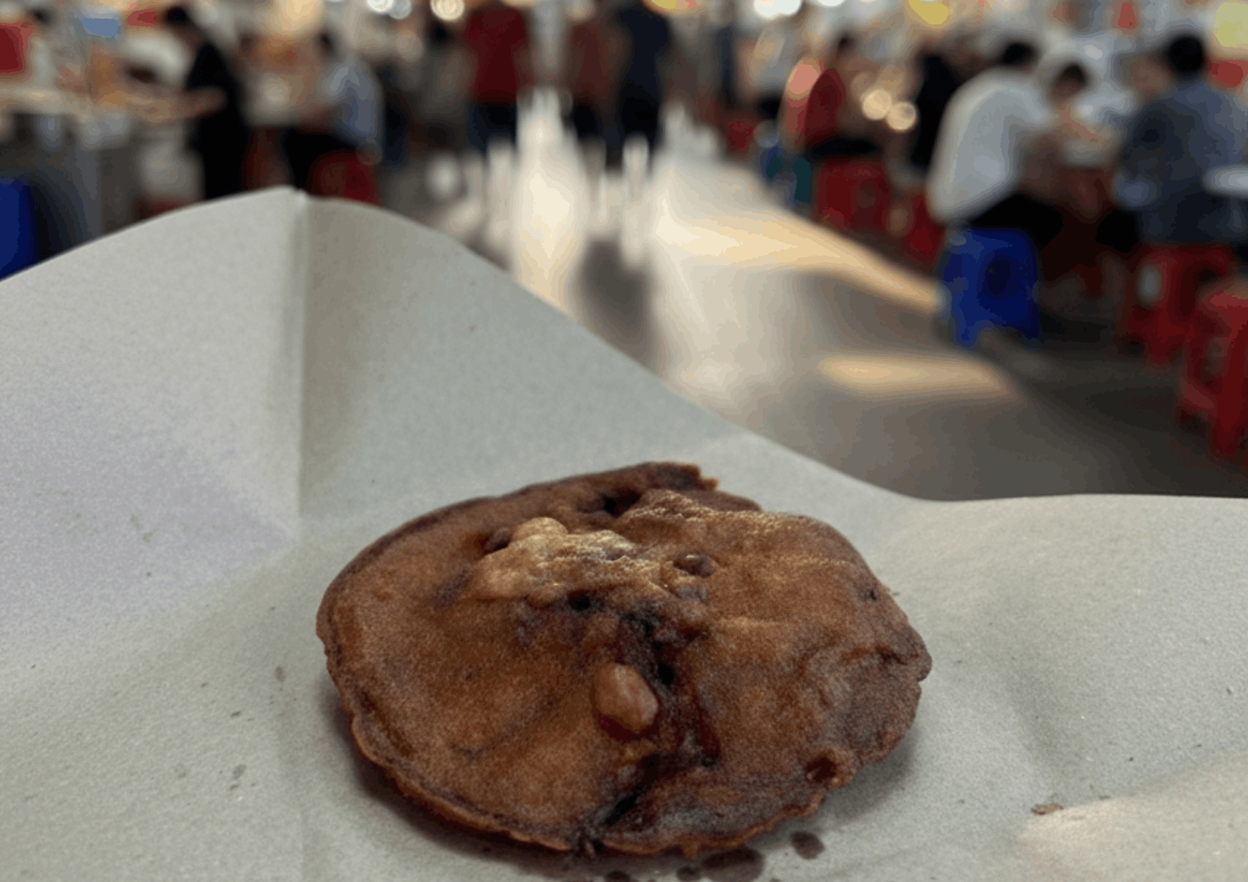 A freshly fried Fuzhou oyster cake from Maxwell Food Centre in Singapore, crispy on the outside and filled with minced meat, oysters, and peanuts.