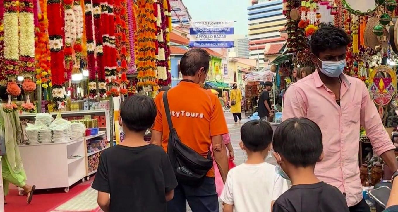 A bustling street in Singapore’s Little India with colorful shophouses and market stalls.