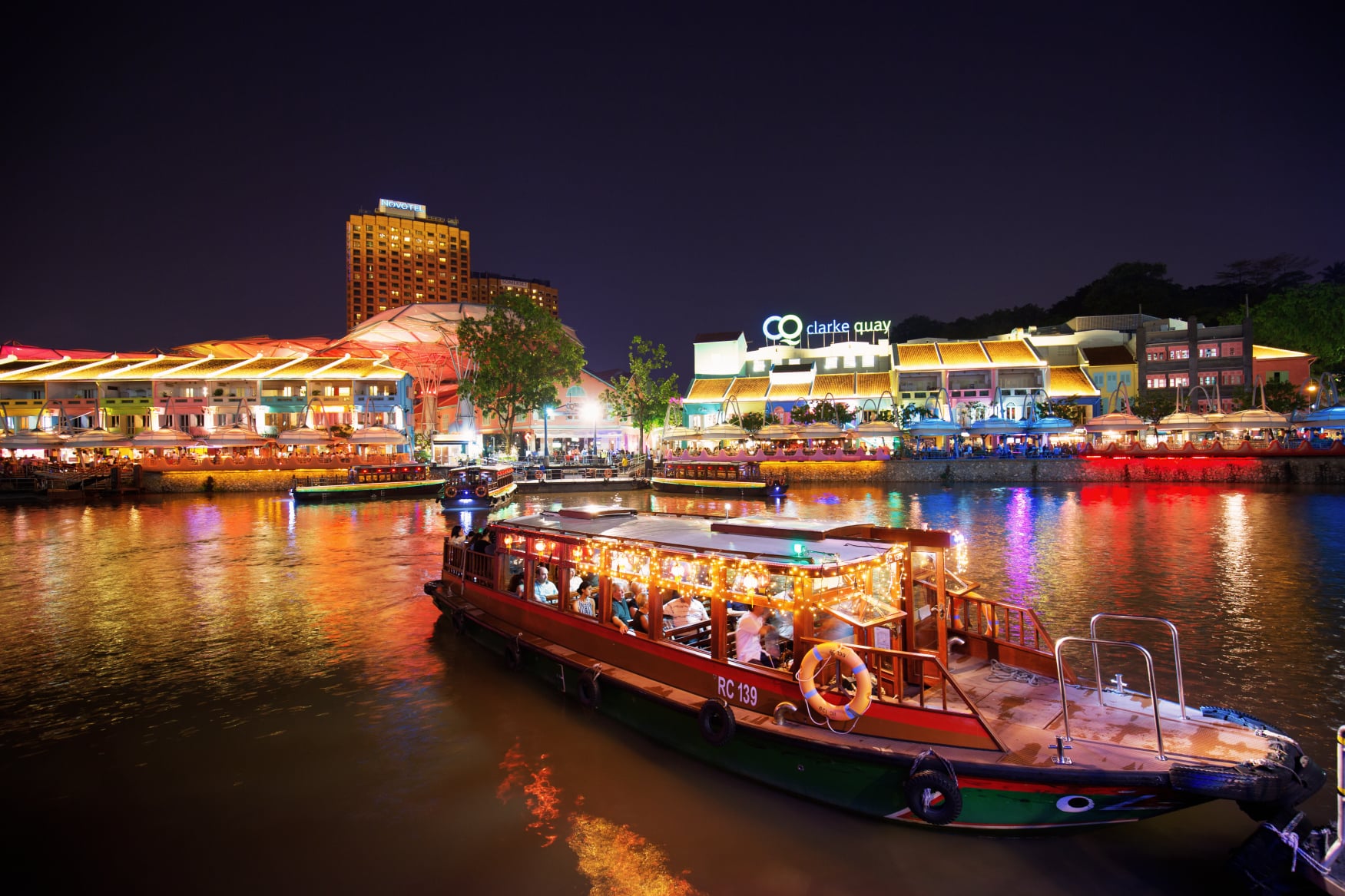 FunVee open-top bus and Singapore River Cruise passing Marina Bay at night – a scenic highlight of the 3-day Singapore Easy Pass itinerary