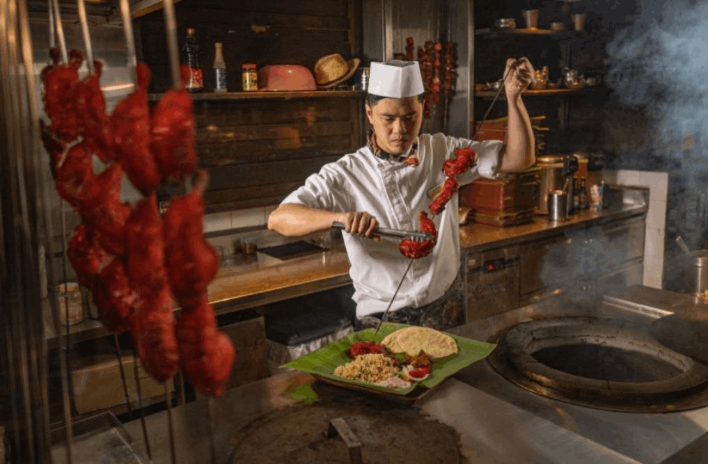 Chef preparing tandoori dishes at Ulu Ulu Asian Buffet Restaurant in Singapore, known for traditional Asian cuisine and authentic ambiance.